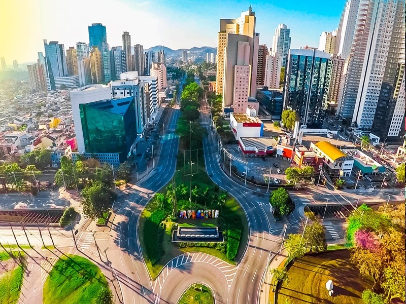 Imagem da cidade de Barueri, com diversos prédios, áreas verdes e paisagismo em um dia ensolarado